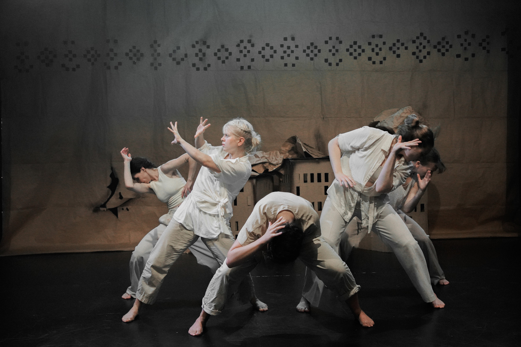 Dance-theatre performers gathered in a flooded landscape